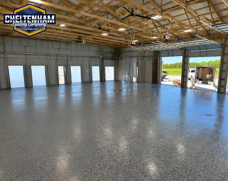 Interior of a large, open commercial space with a newly coated, glossy gray floor.