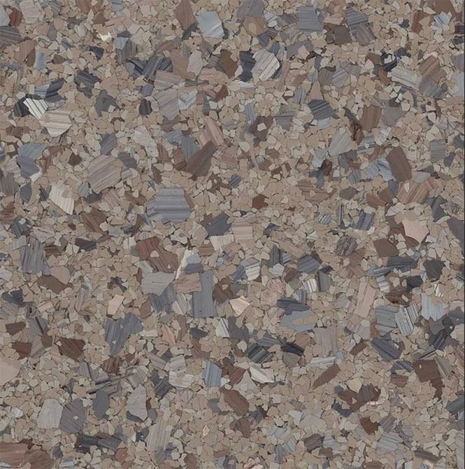 Multi-colored speckled flooring with brown, gray, and beige flakes.