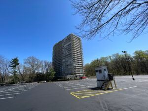 A parking lot with a tall building in the background.
