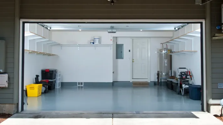 A garage with the door open and lots of storage space.