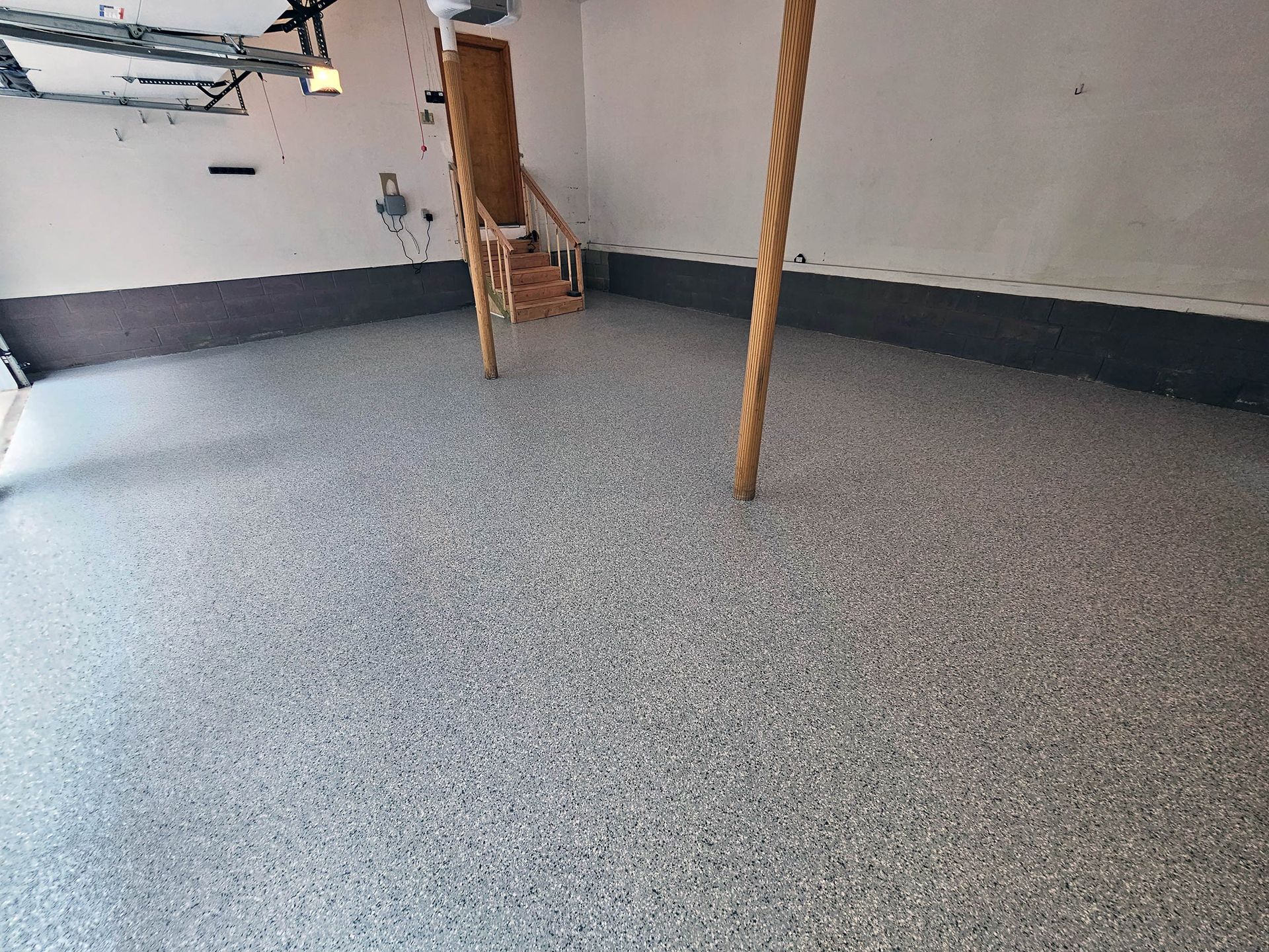A garage with a concrete floor and a rope hanging from the ceiling.