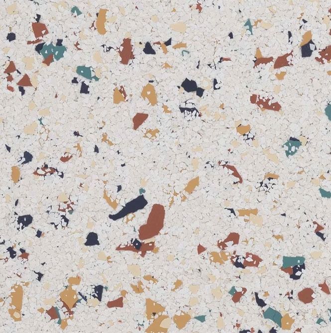 White surface with scattered specks in teal, brown, tan, and navy.