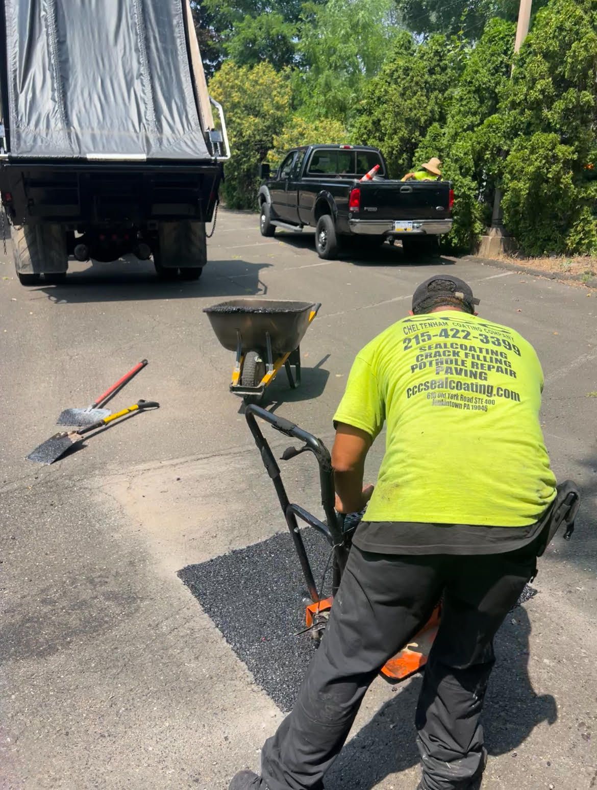 A patch of asphalt is sitting on the ground next to a yellow line.