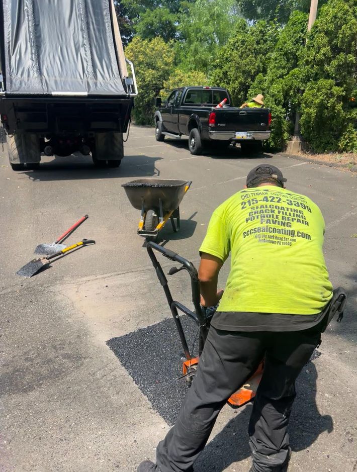 A patch of asphalt is sitting on the ground next to a yellow line.