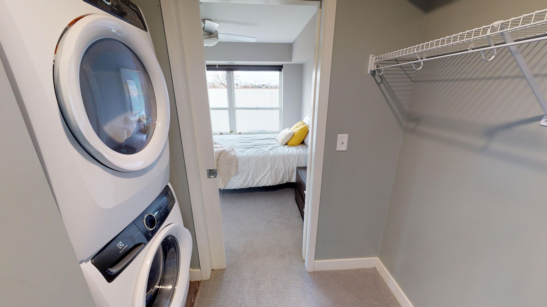 Closet of apartment bedroom with washer and dryer.