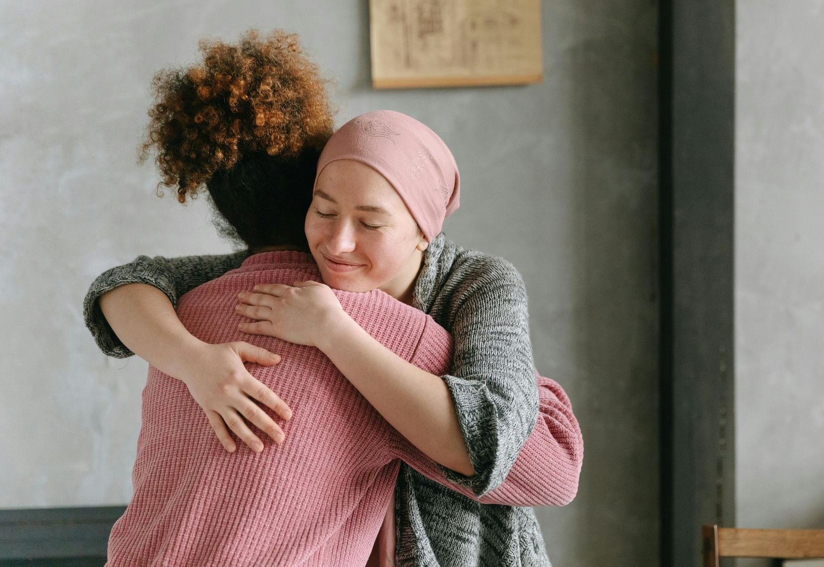 A woman with cancer is hugging another woman.