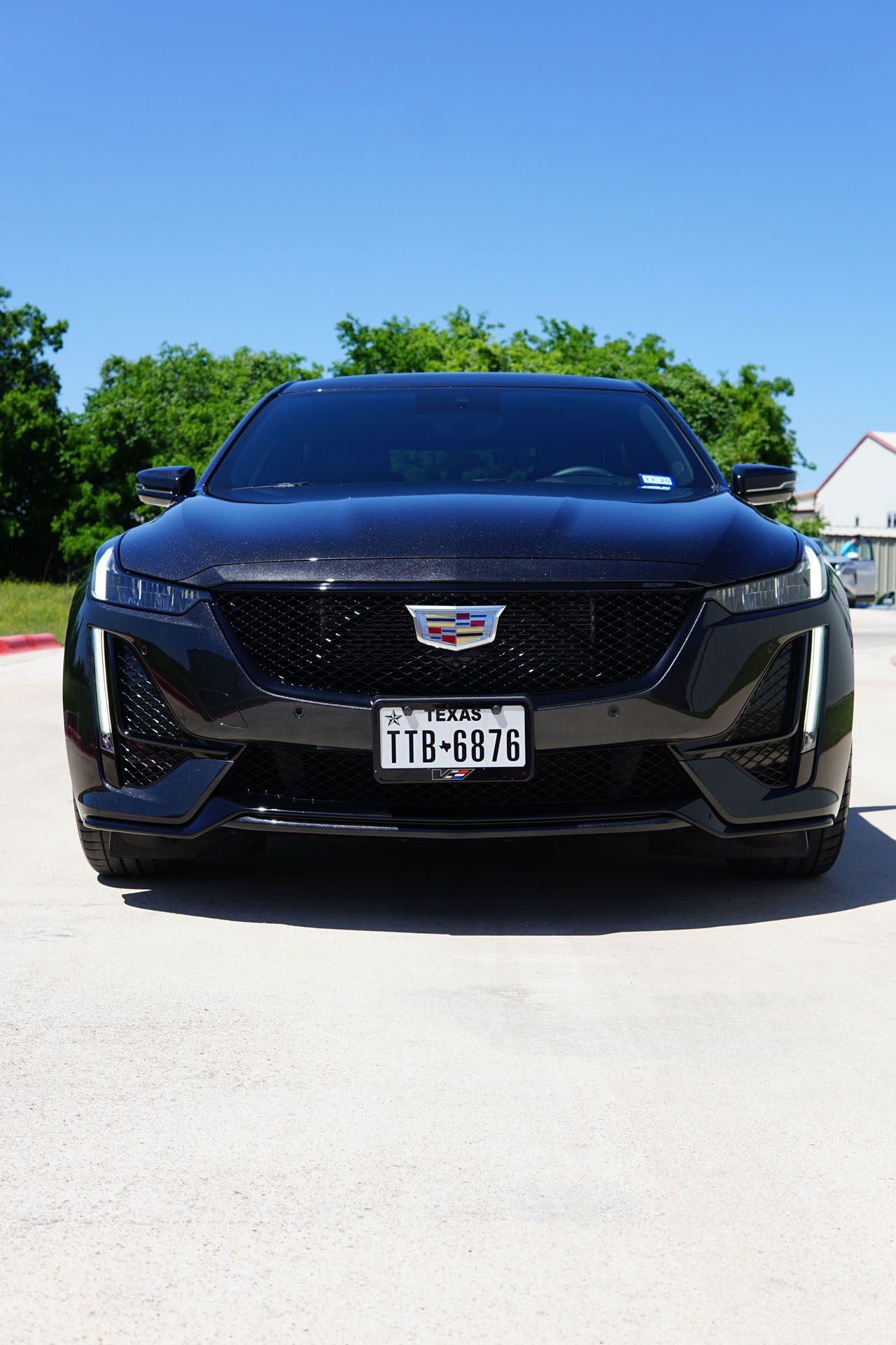 A black cadillac is parked in a parking lot