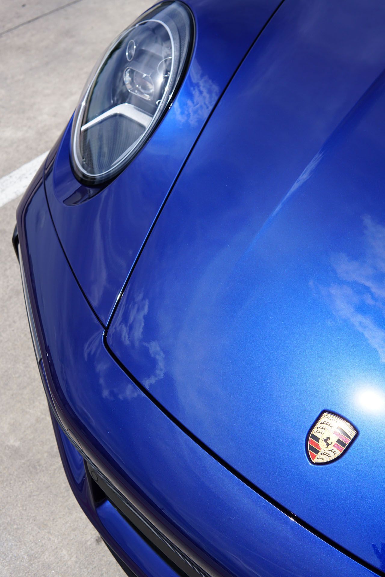 A close up of the front of a blue porsche