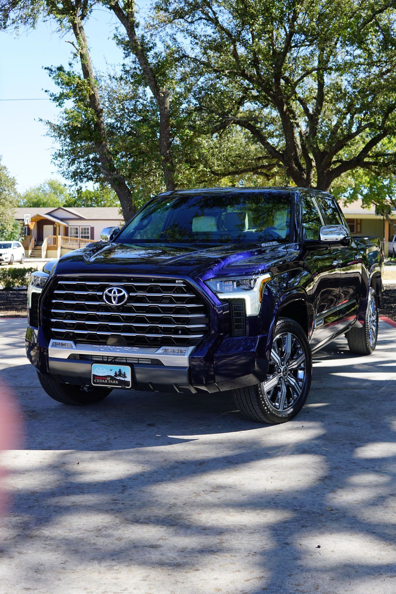 A purple truck is parked on the side of the road.