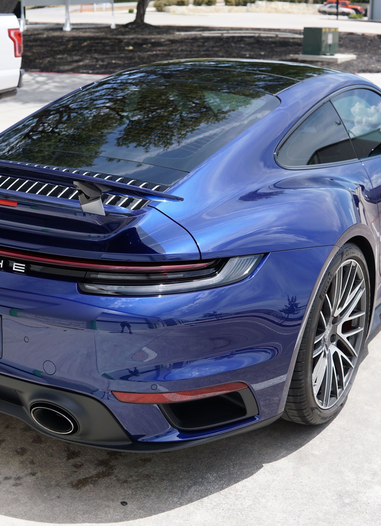 A blue porsche 911 turbo is parked in a parking lot.