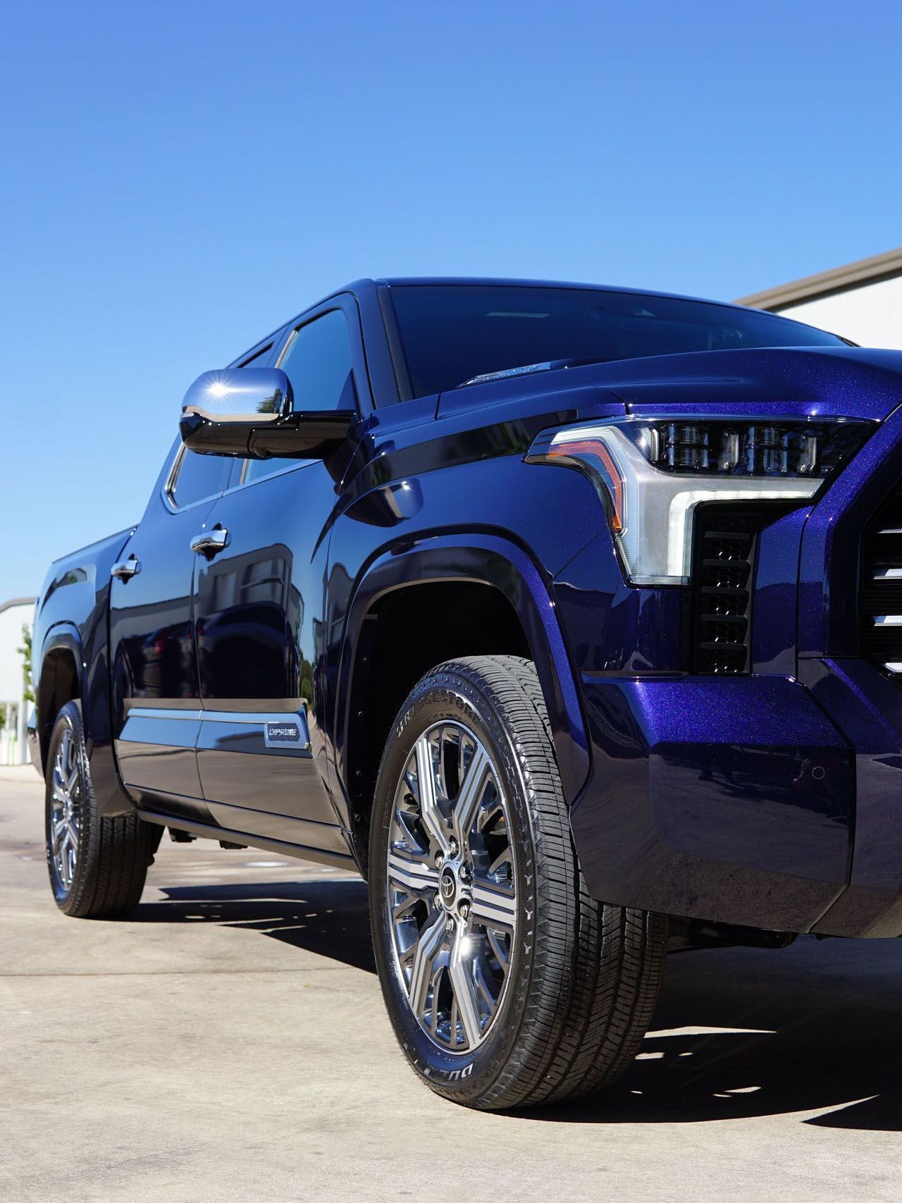 A purple truck is parked on the side of the road.