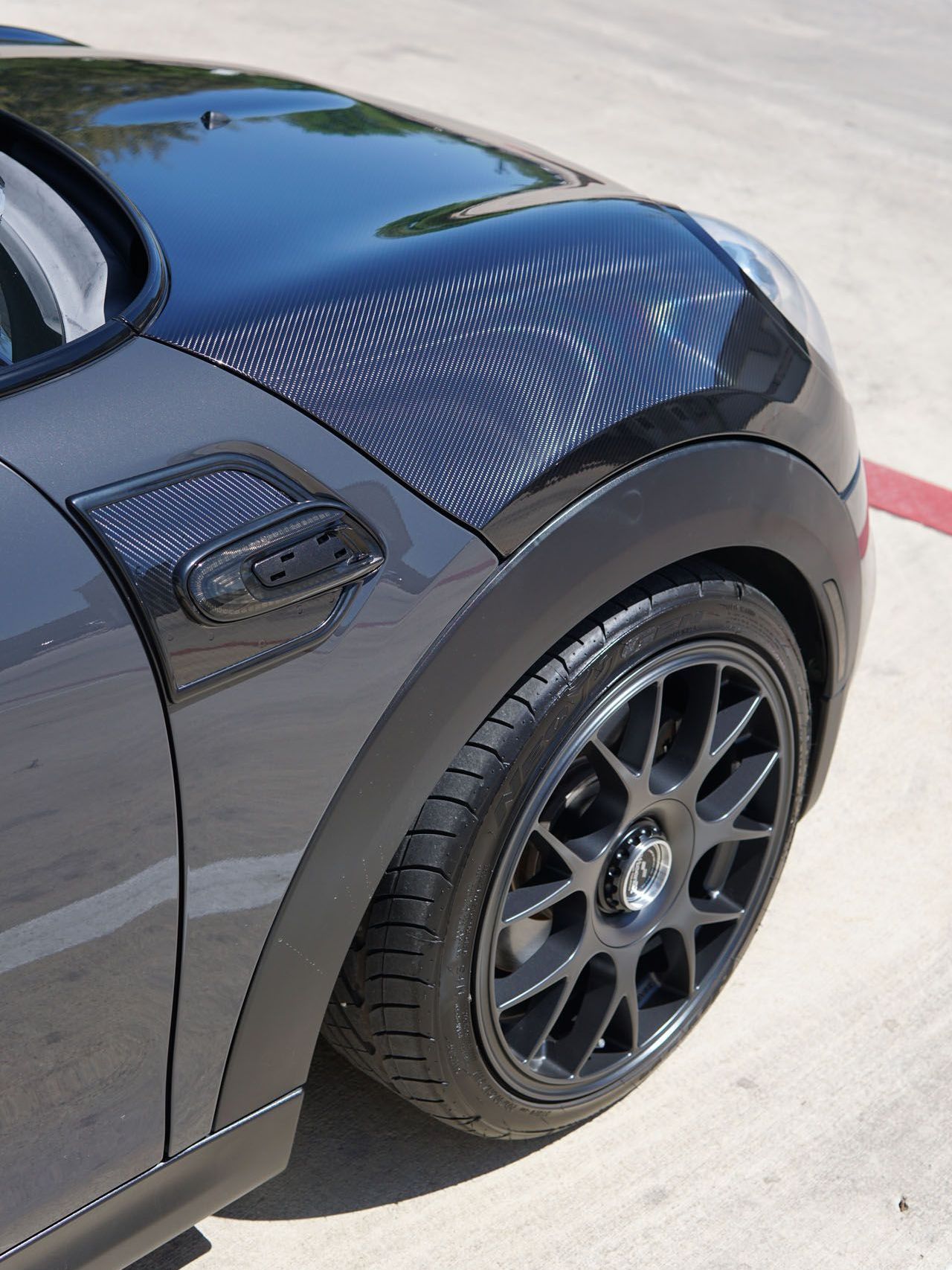 A black mini cooper is parked in a parking lot