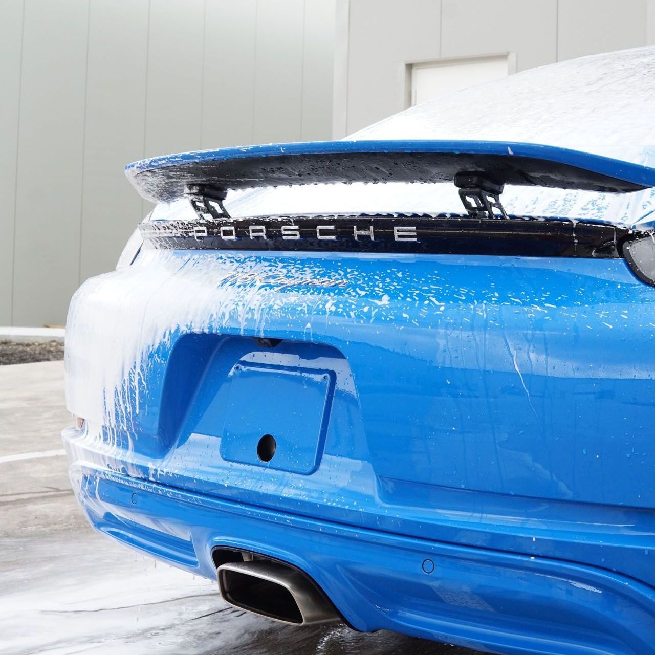 A blue porsche car is parked in the snow