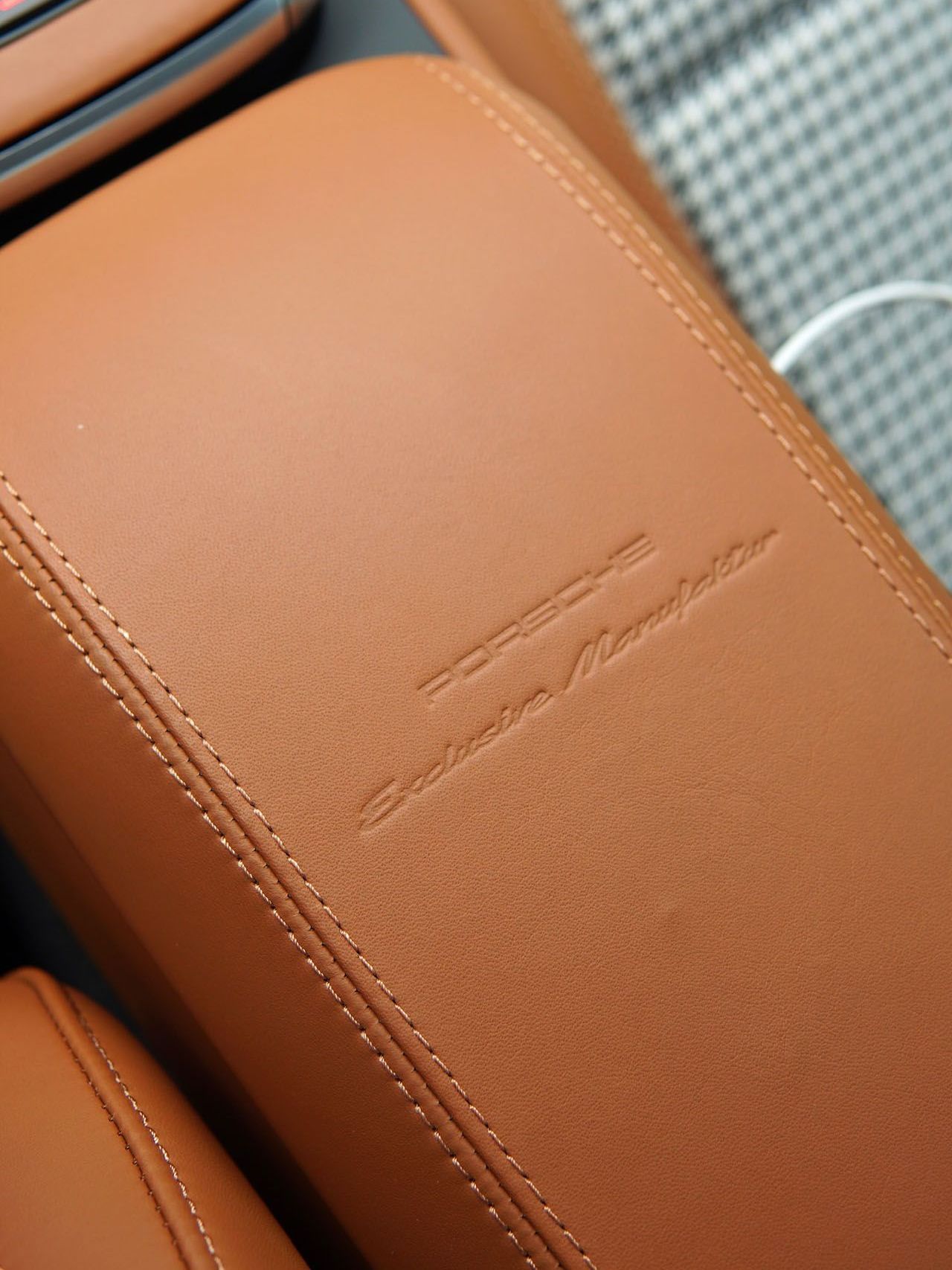 A close up of a brown leather arm rest in a car.