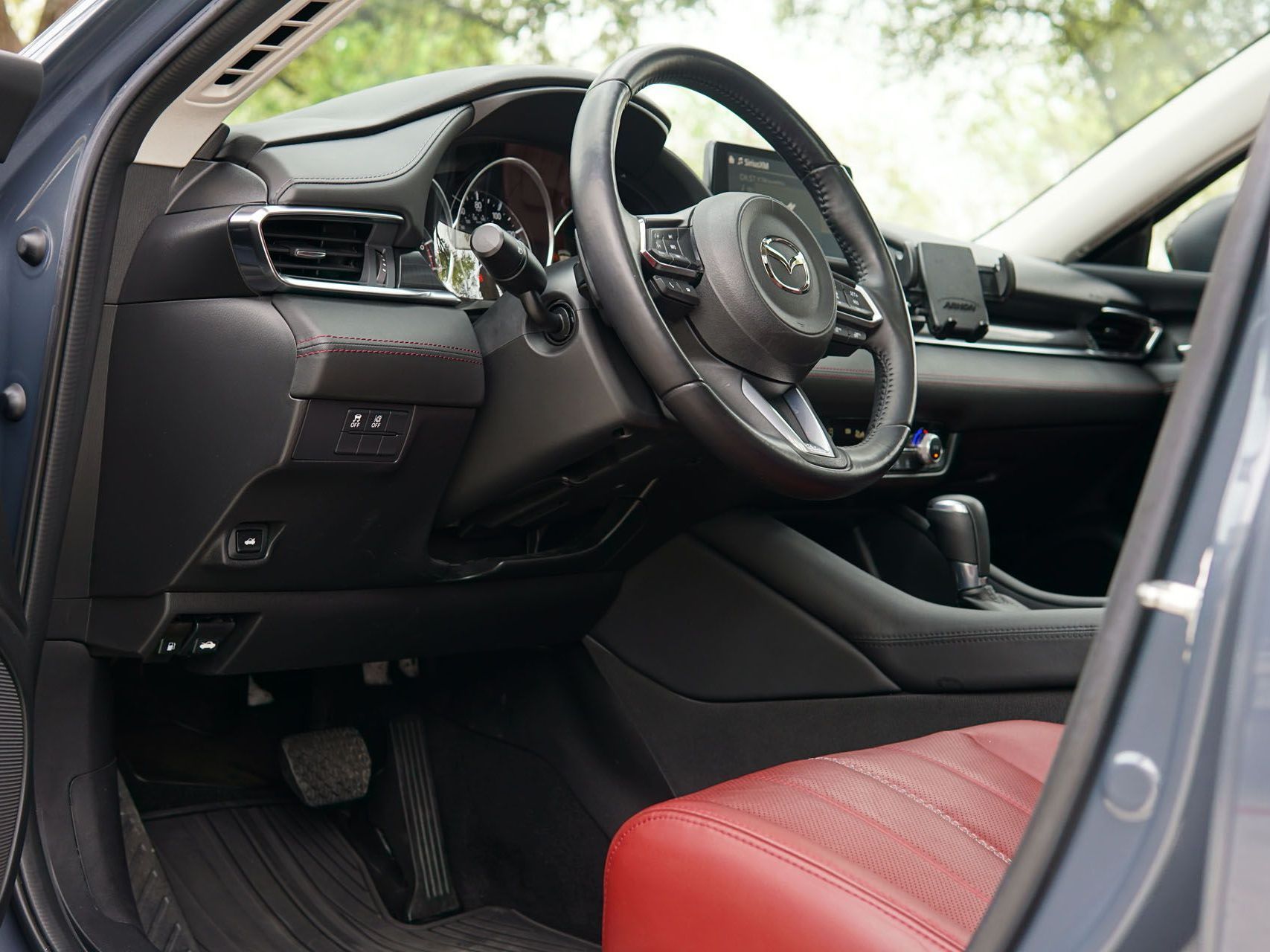 The interior of a car with a red seat and steering wheel