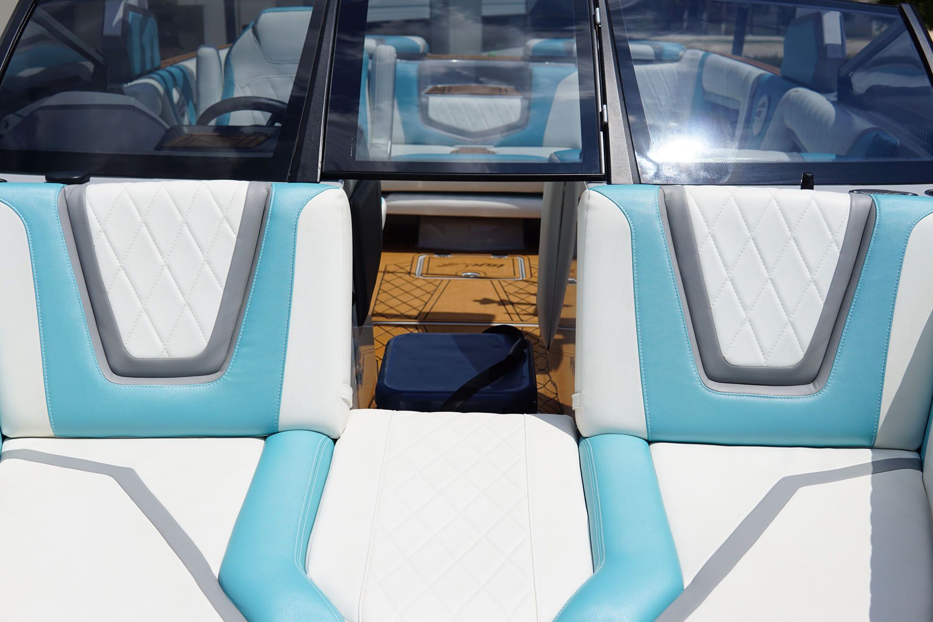 The inside of a boat with blue and white seats.