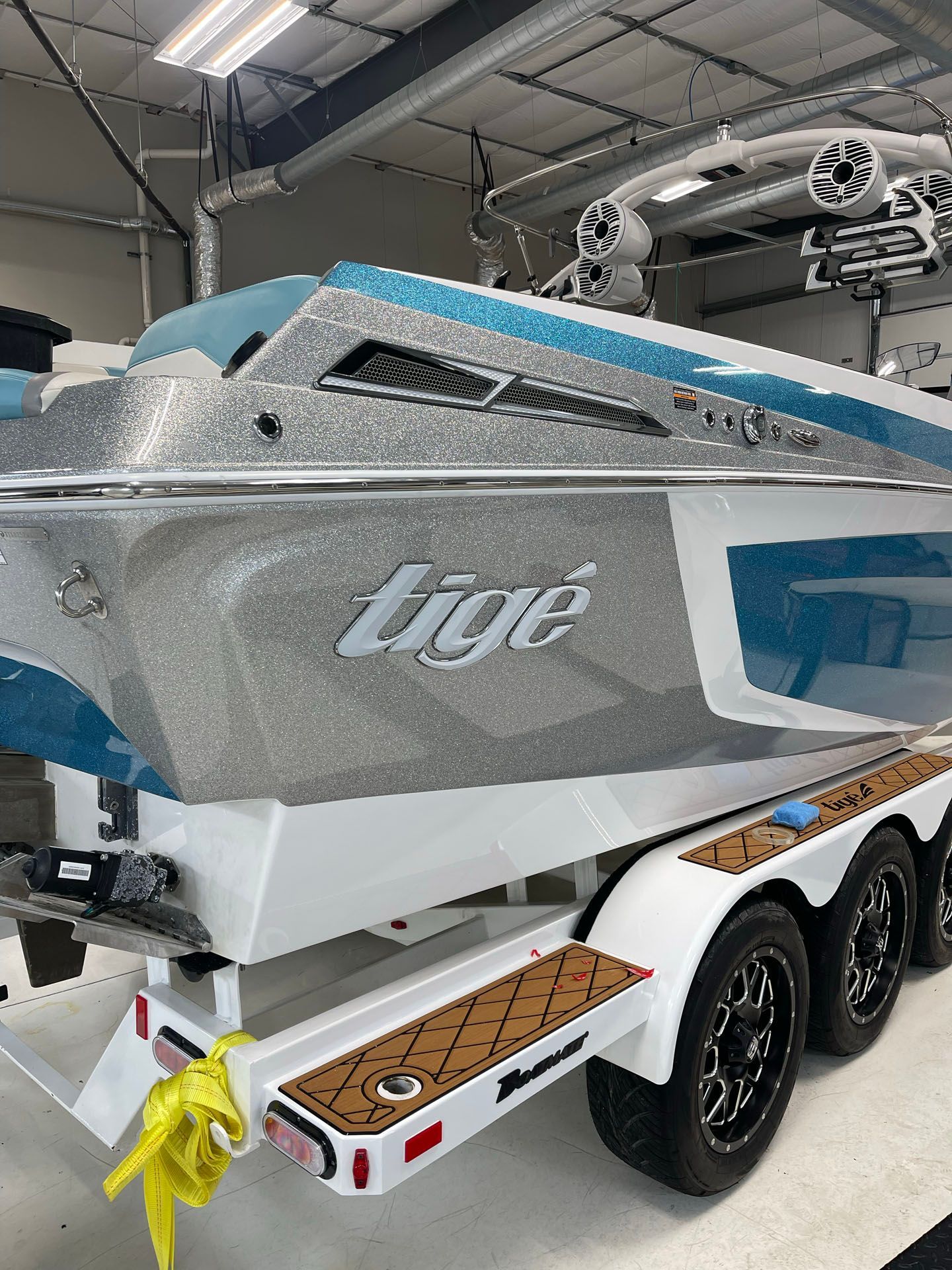 A boat is parked on a trailer in a garage.