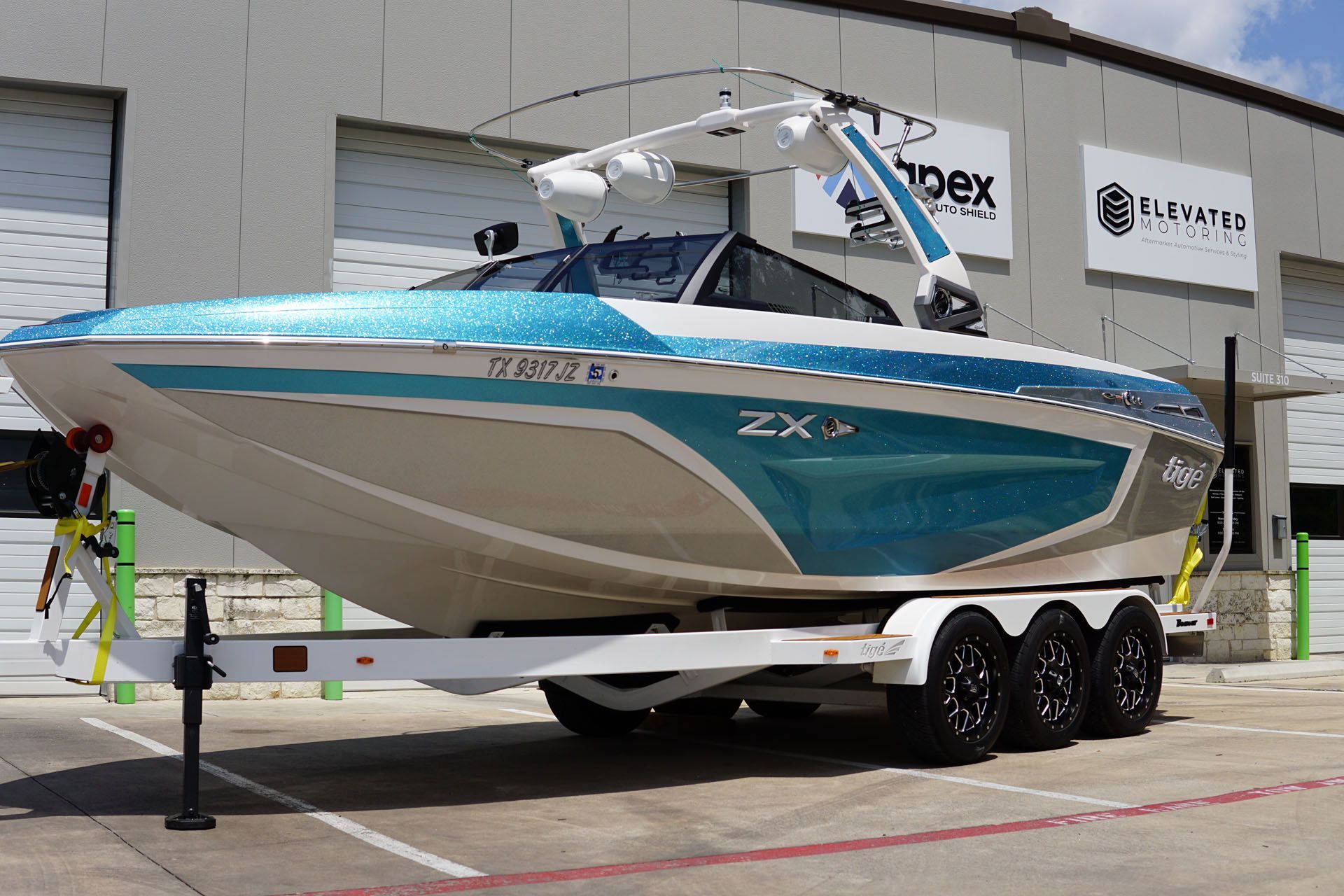 A blue and white boat is parked in front of a building.