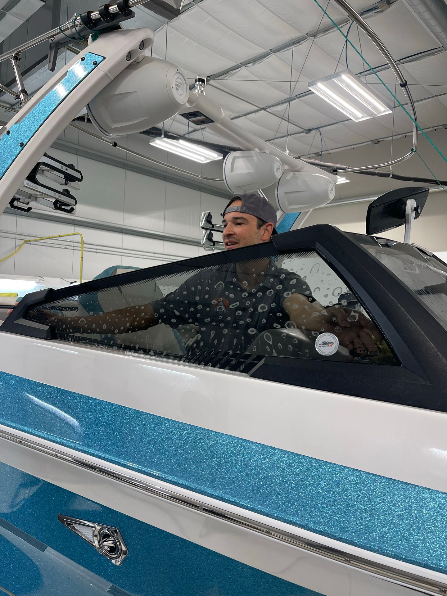 A man is sitting in the driver 's seat of a boat.