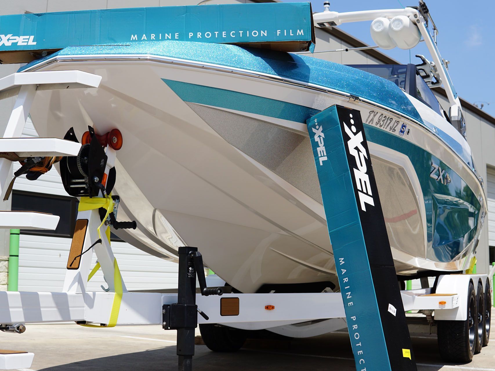 A boat is sitting on a trailer with a sticker that says marine protection film