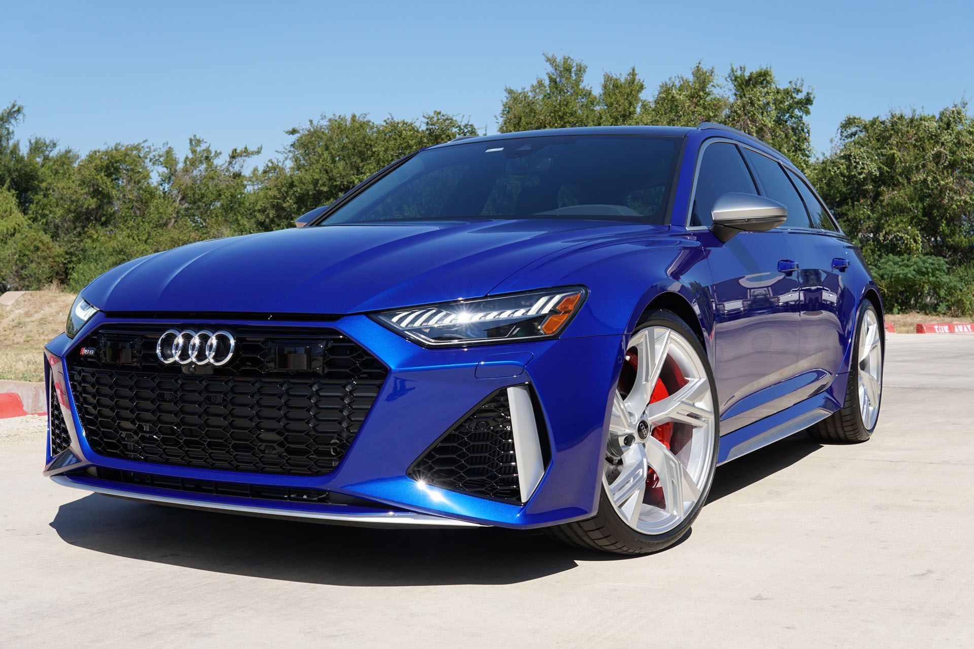 A blue audi rs6 is parked on the side of the road.