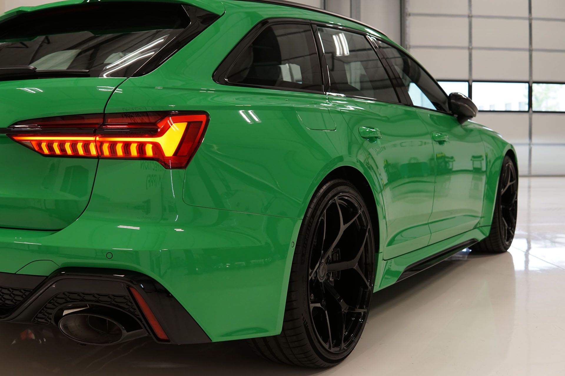 A green audi rs6 is parked in a garage.