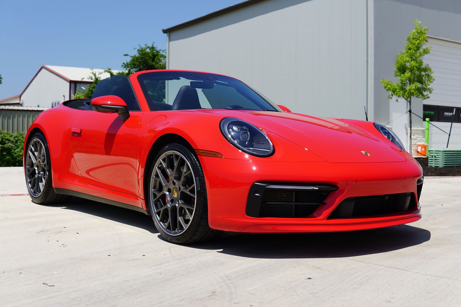 A person is cleaning a car with a blue sponge