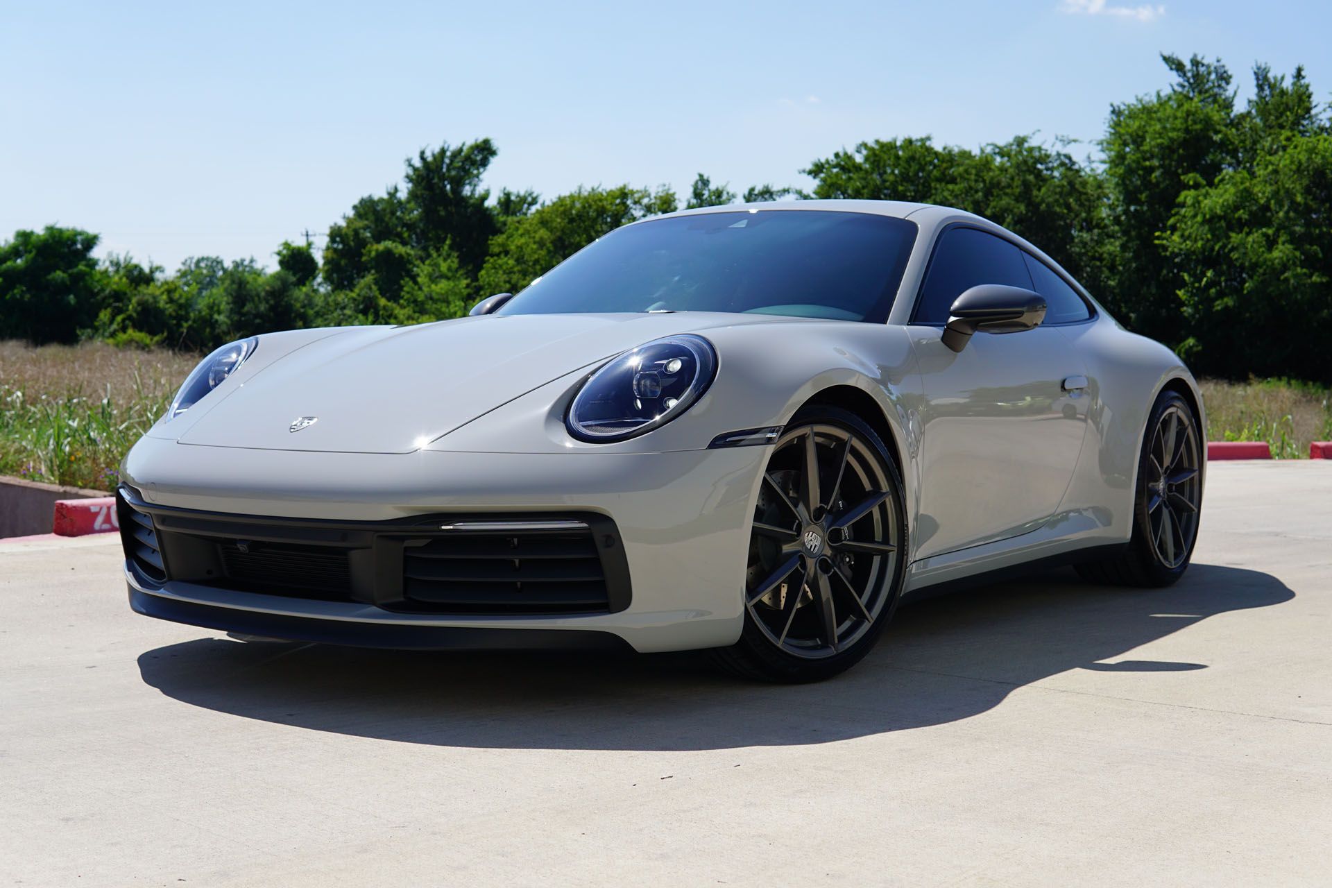 A person is cleaning a car with a blue sponge