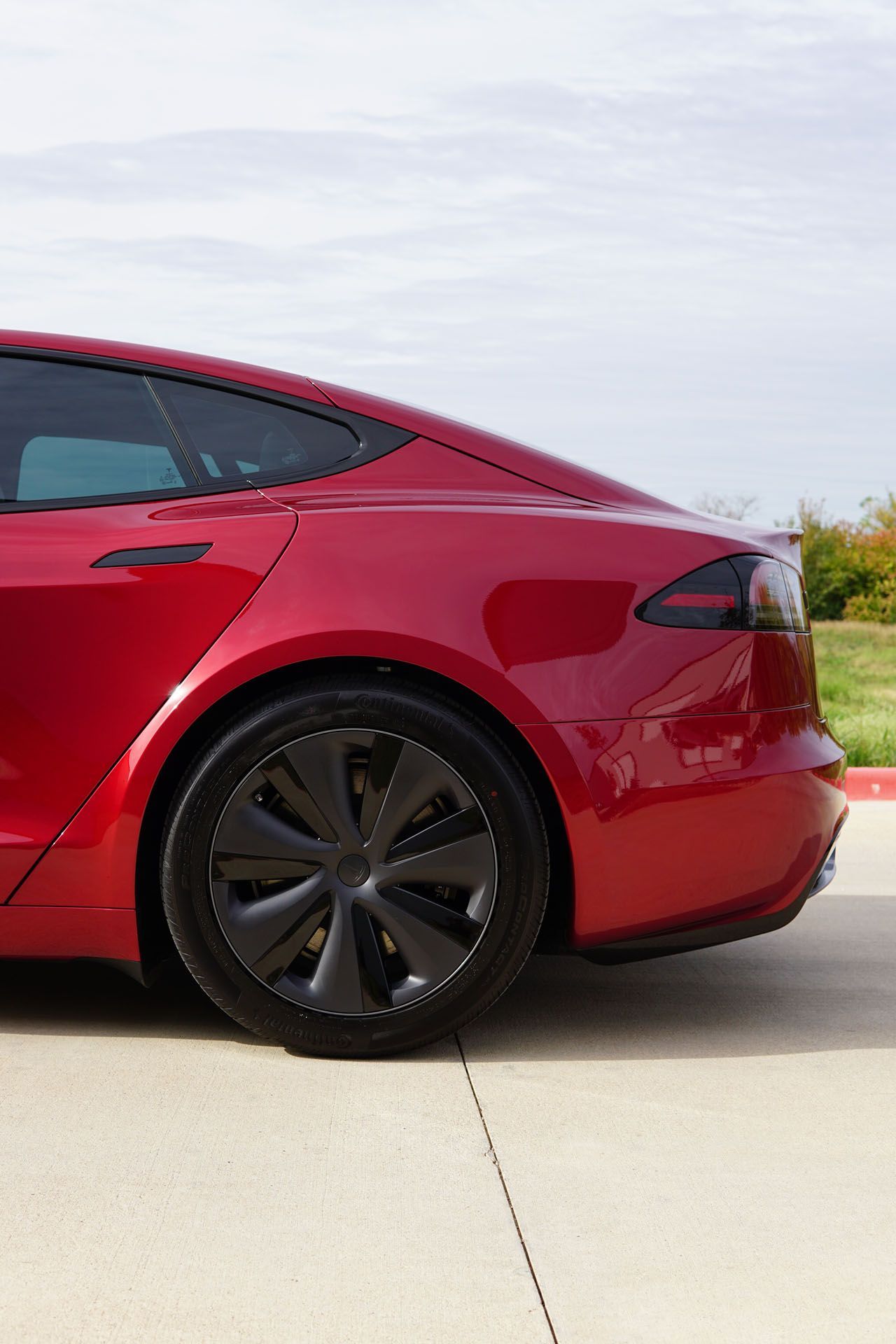 A black car is being worked on by a person in a garage.