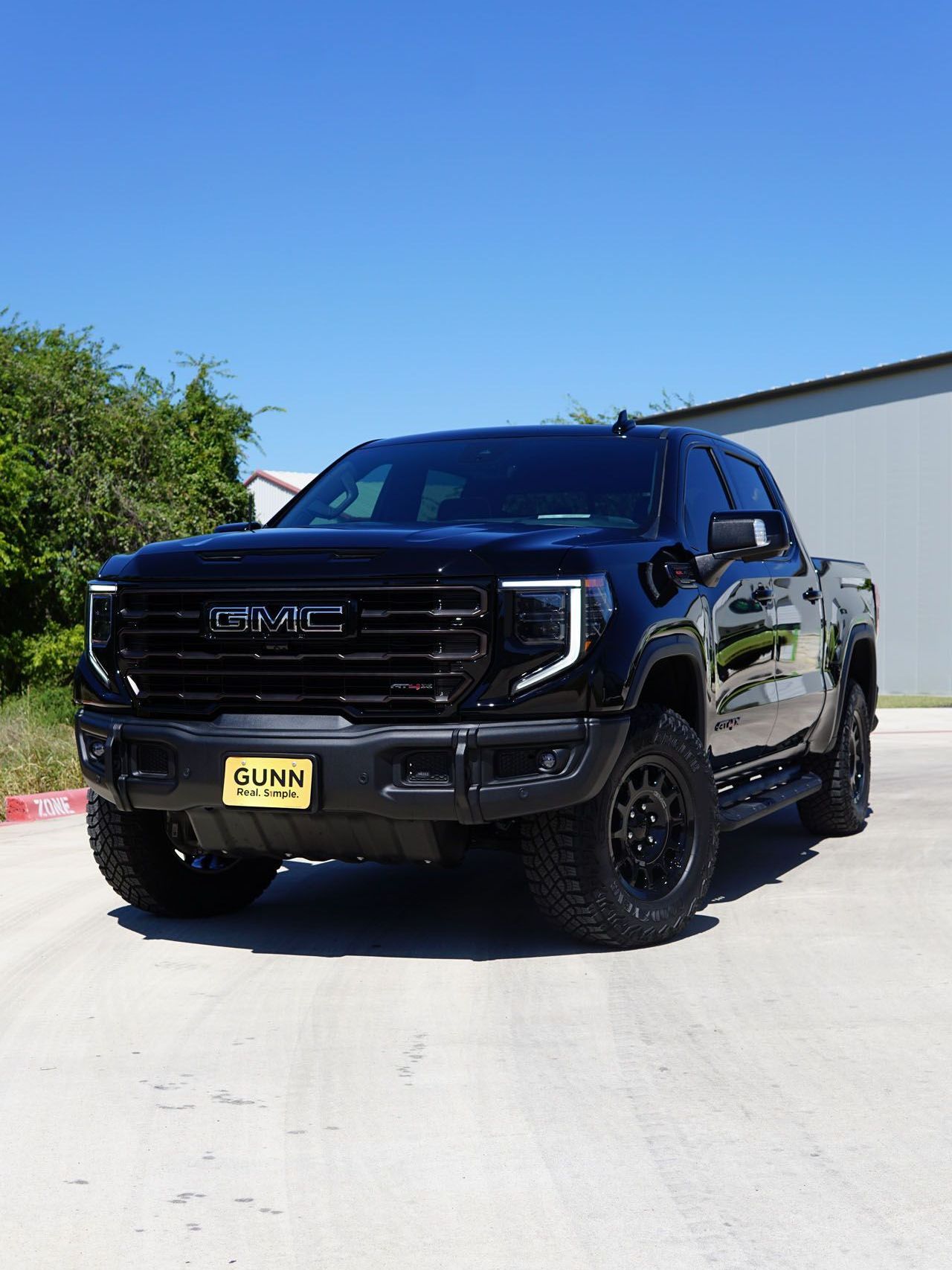 A black gmc truck is parked in a parking lot.