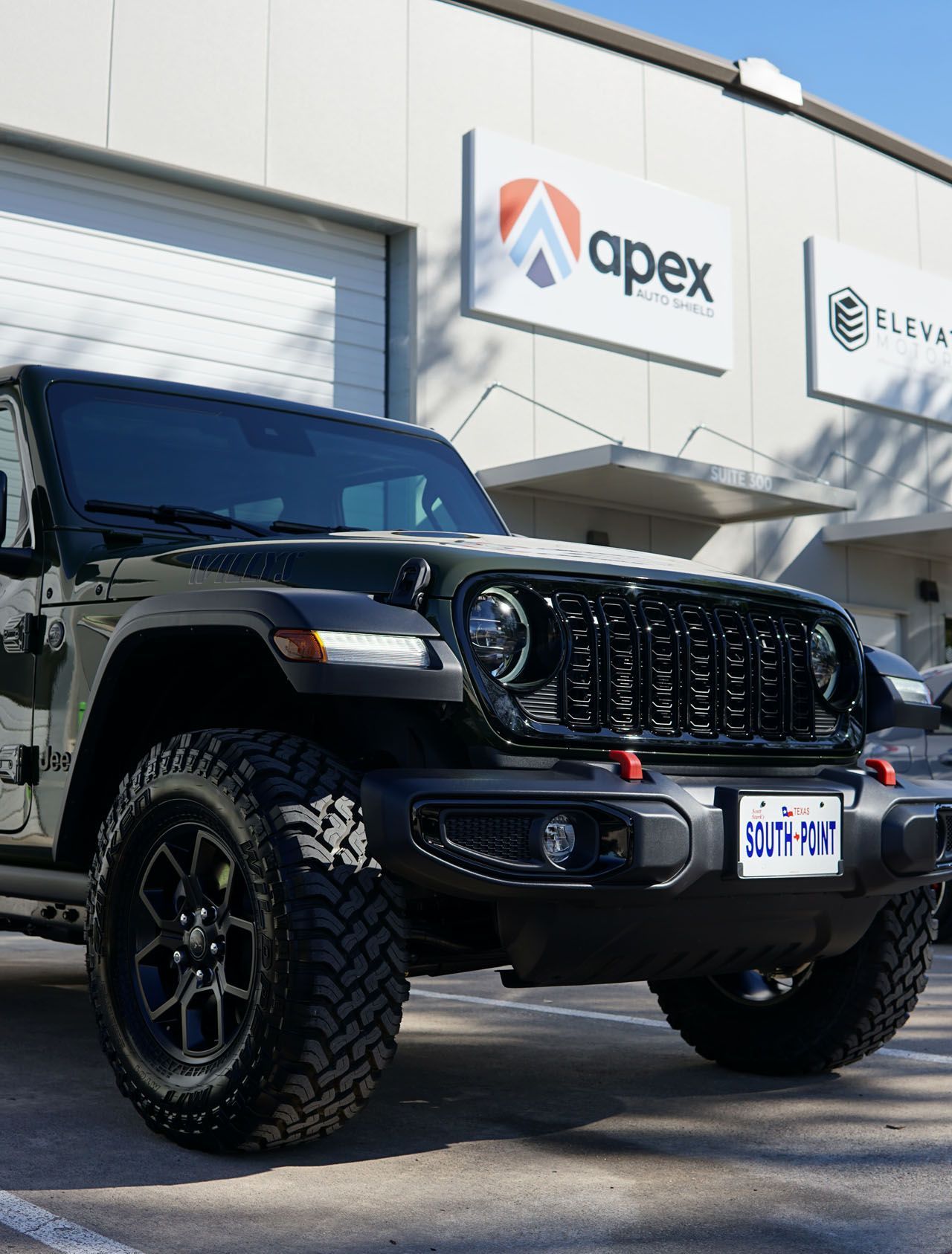 A jeep is parked in front of an apex building