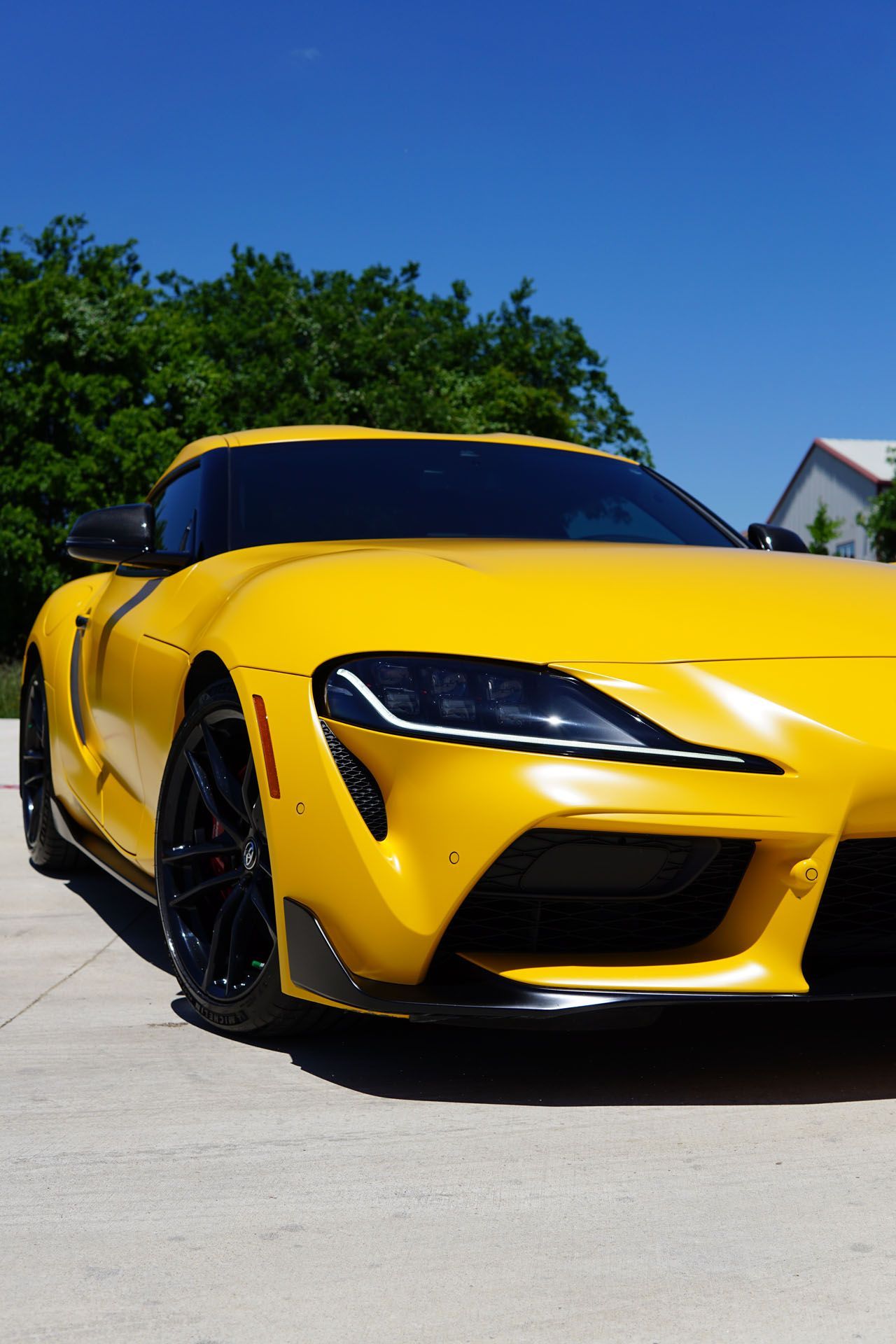 A yellow sports car is parked on the side of the road