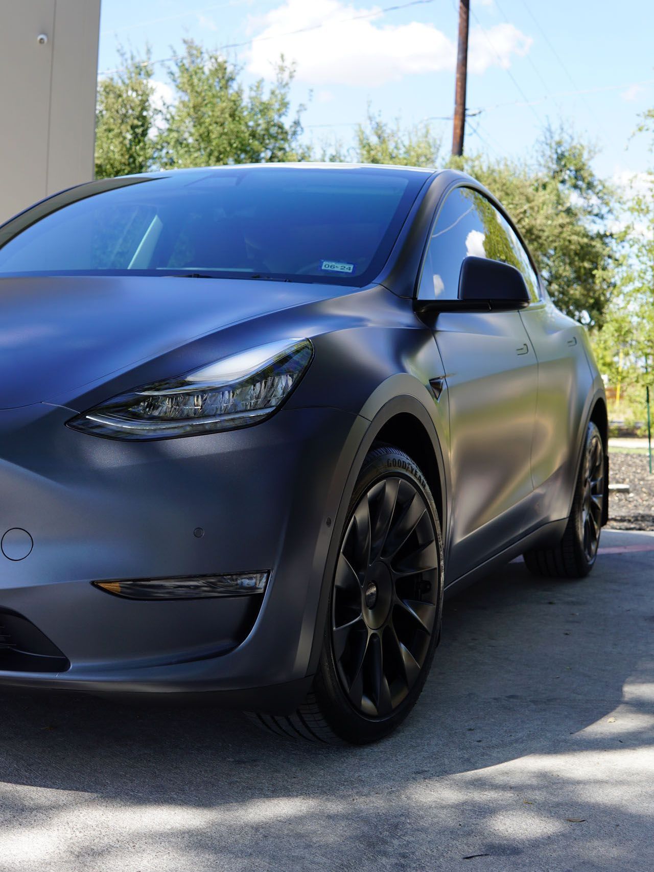 A green car with black wheels is parked in a garage.