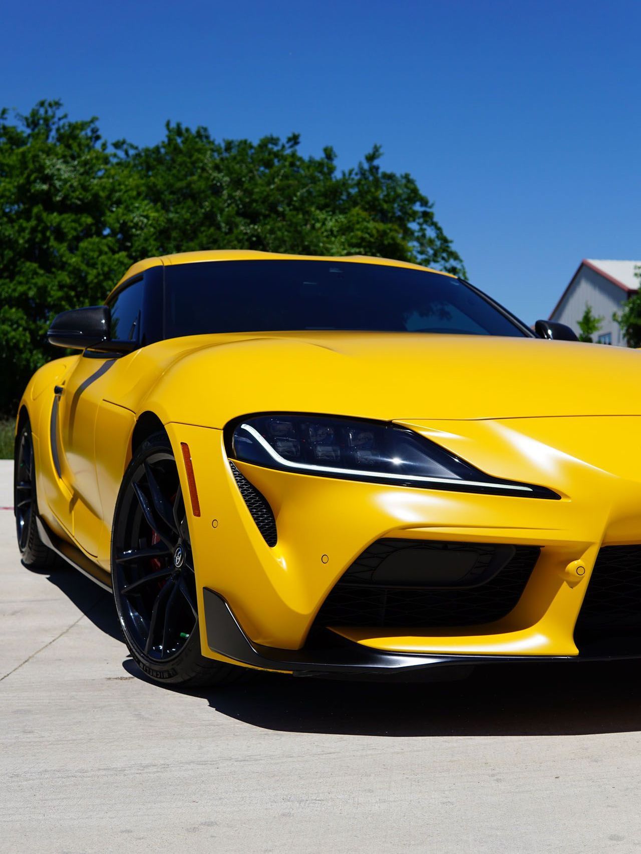 A yellow sports car is parked on the side of the road