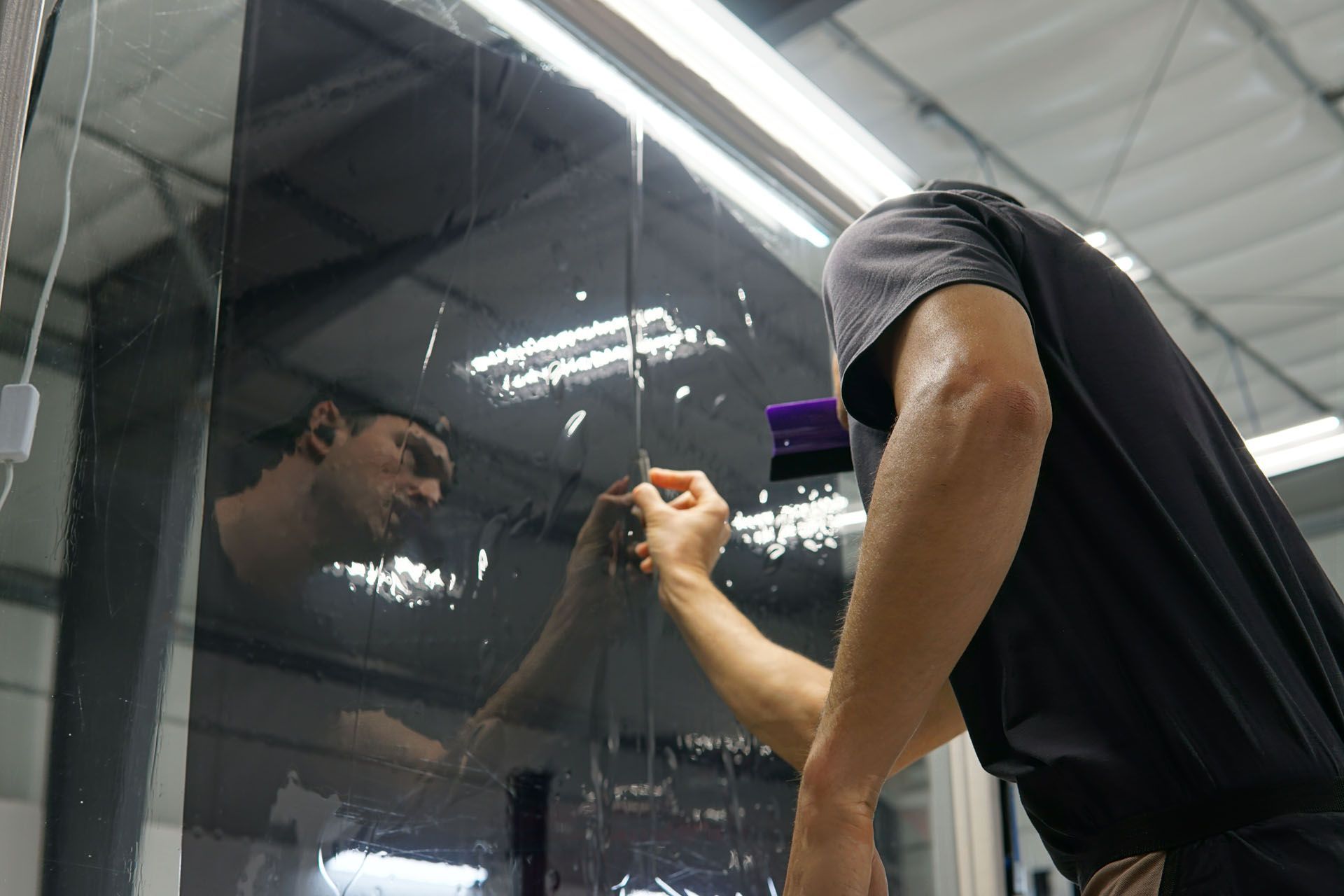 A man is cleaning a car window with a cloth