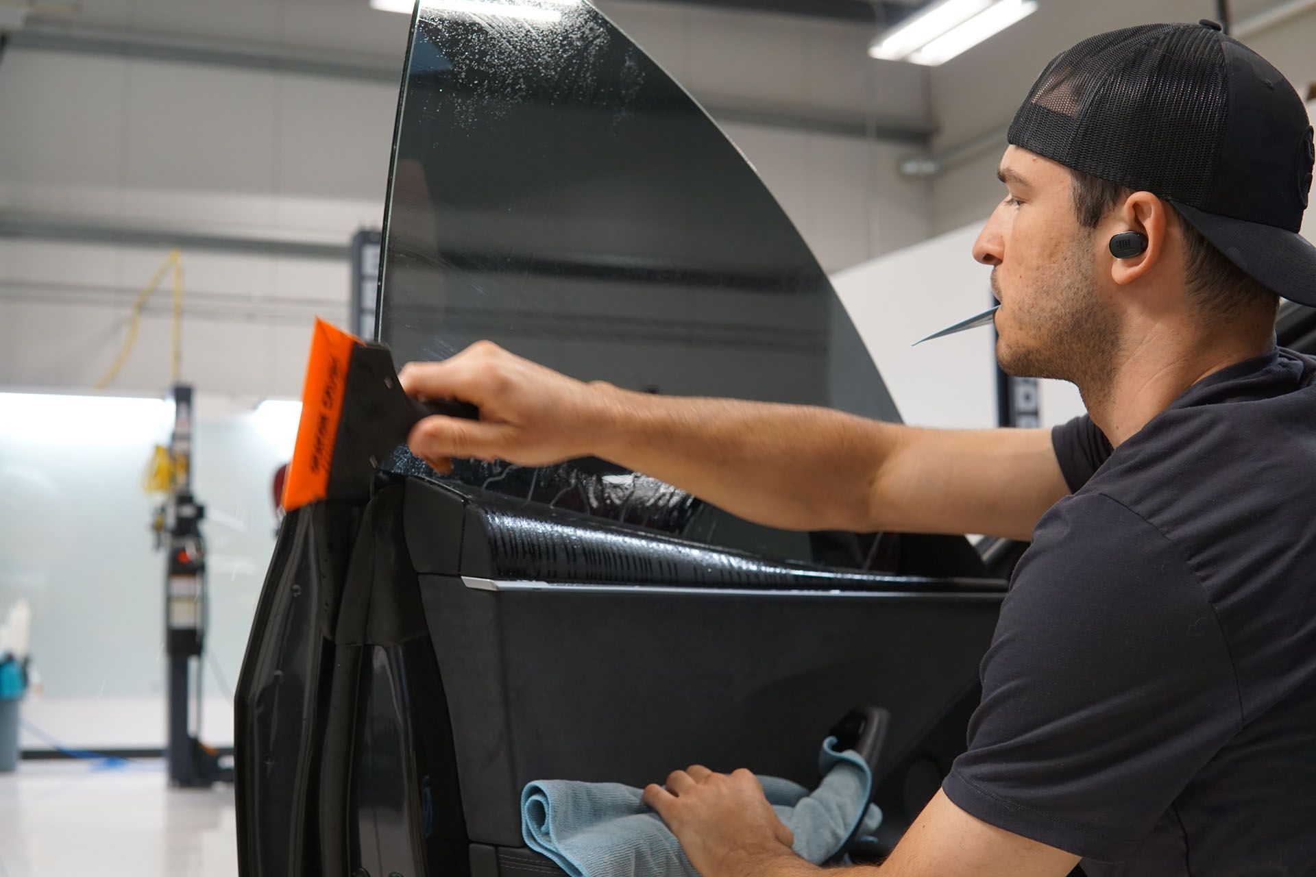 A man is cleaning a car window with a cloth