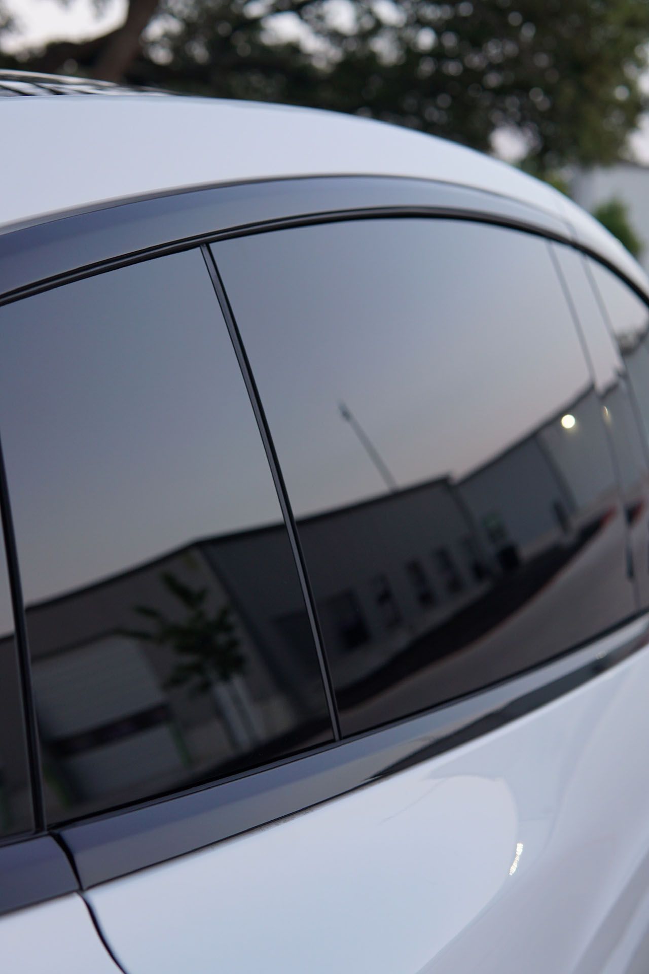 A close up of a car window with a reflection of a building