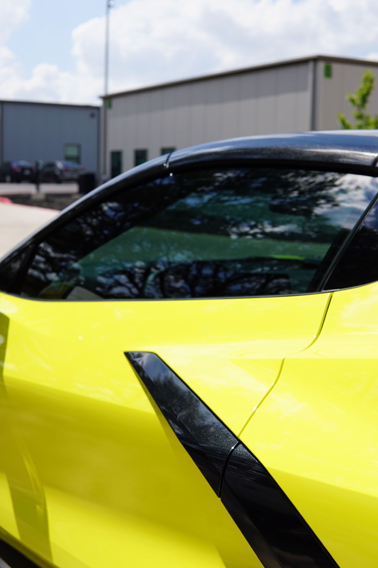 A yellow sports car is parked in front of a building