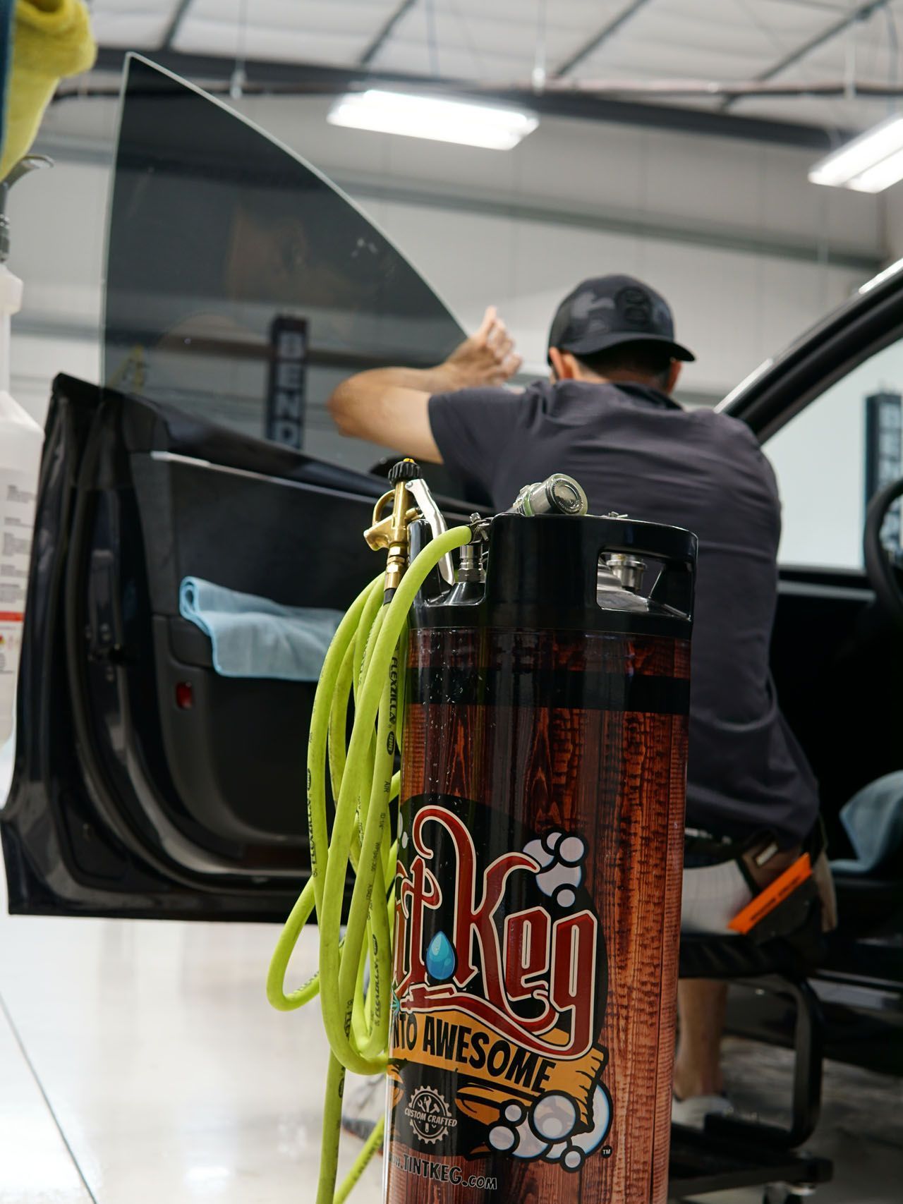 A man is sitting in a car next to a can that says key awesome