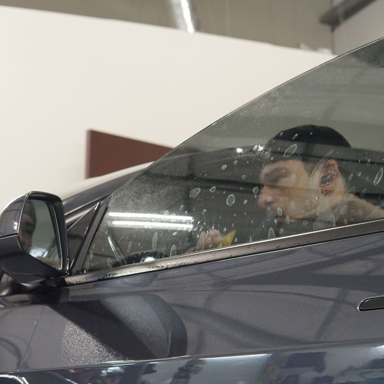 A man is applying window tinting to a car door