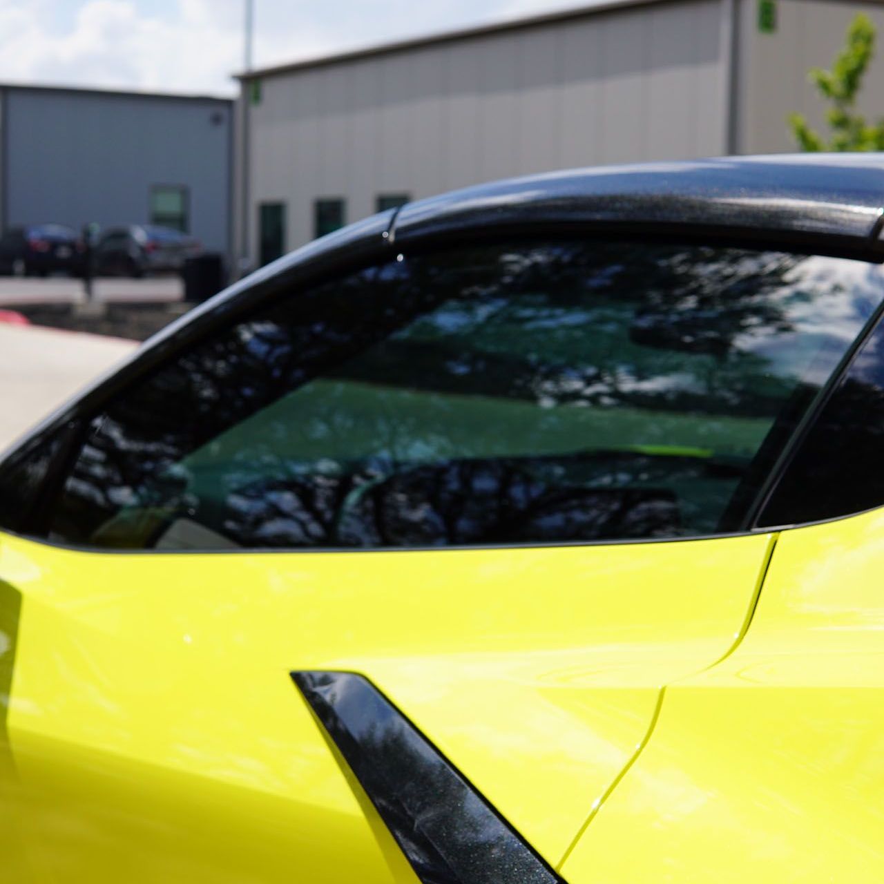 A man is applying window tinting to a car door