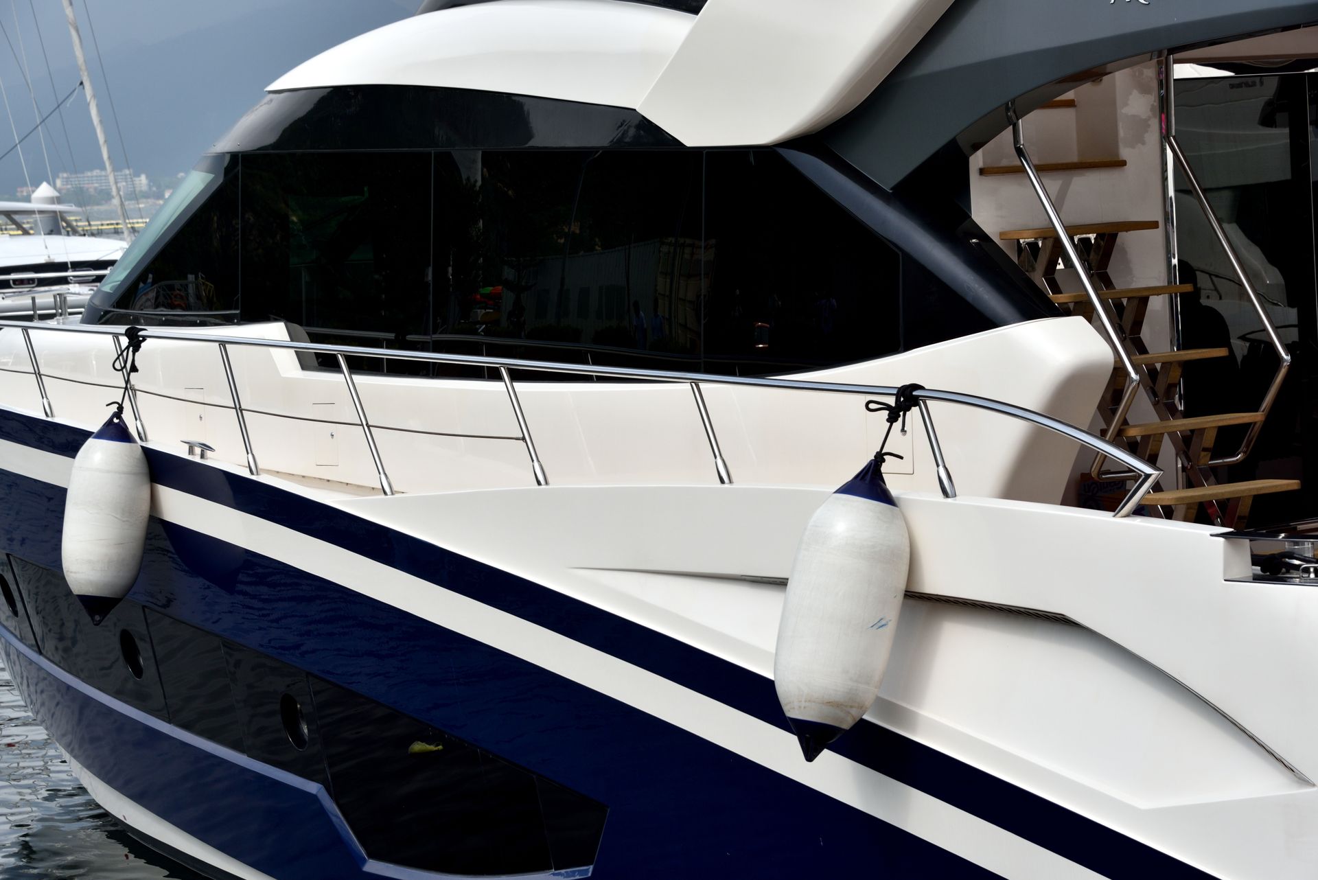 A blue and white boat with a white fender on the side