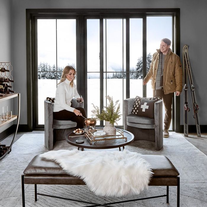 A man and a woman are sitting in chairs in a living room.