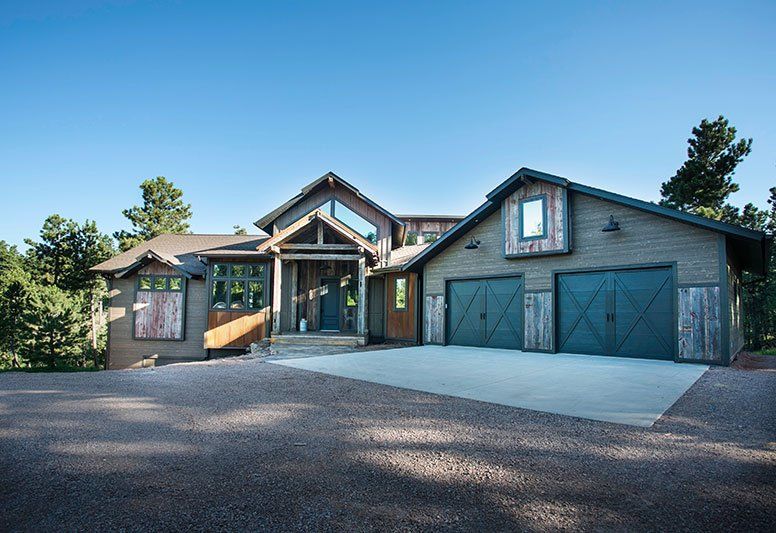A large house with two garages is sitting on top of a hill.