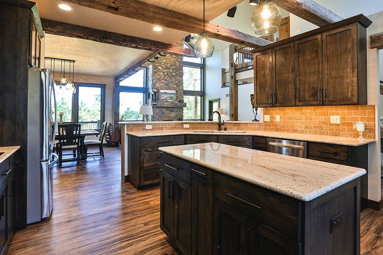 A kitchen with wooden cabinets , granite counter tops , and stainless steel appliances.