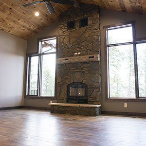 There is a large stone fireplace in the middle of the room.