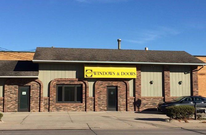 A building with a yellow sign that says windows and doors