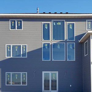 The back of a house with a lot of windows and doors.
