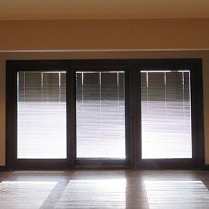 A room with three windows and blinds on them.