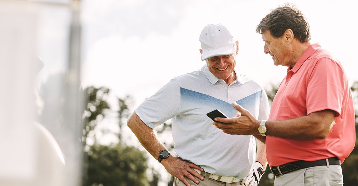 Two golfers looking at phone